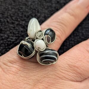 This elegant sterling silver ring features a floral design adorned with alternat